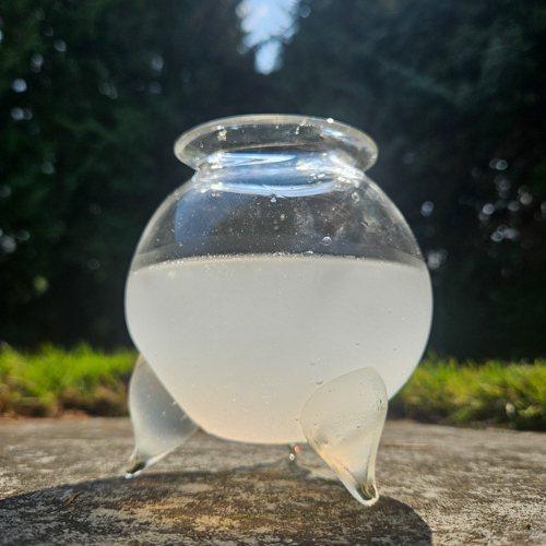Cauldron containing white liquid on grass