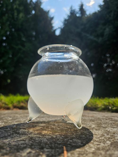Cauldron containing white liquid on grass